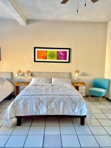 1 dormitorio con 1 cama y una pintura en la pared en Casa Dei Girasoli, en Cabo San Lucas