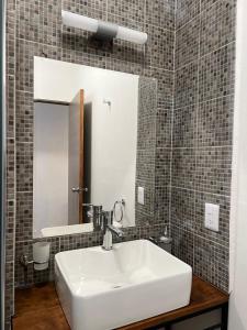 a bathroom with a white sink and a mirror at Casa Dei Girasoli in Cabo San Lucas