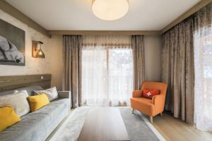 a living room with a couch and a chair at Résidence Premium L'Hévana - maeva Home - Appartement 3 pièces 7 personnes Prestige MAE-5155 in Les Allues +26 photos