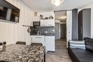 a living room with a table and a kitchen at Studio 4 personnes avec terrasse vue montagne à Vars 103282 in Vars