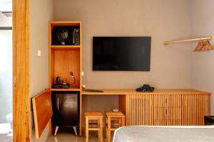 a room with a tv and a desk with stools at JQY Beach Flats - 950m da Praia - Garagem subterrânea - Estação de carregamento para veículos elétricos in Juquei