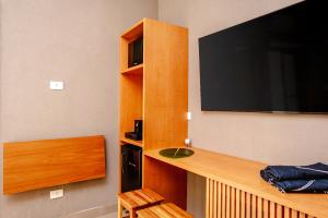 a room with a large flat screen tv on the wall at JQY Beach Flats - 950m da Praia - Garagem subterrânea - Estação de carregamento para veículos elétricos in Juquei
