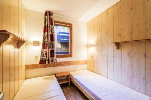 a small room with two beds and a window at Résidence Les Brigues - maeva Home - Appartement 2 pièces 6 personnes Confo 92 in Courchevel