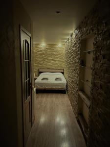 mały pokój z łóżkiem i ceglaną ścianą w obiekcie Valmiera City Center Budget Apartment w mieście Valmiera