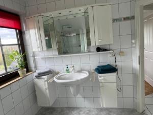 ein Bad mit einem Waschbecken und einem Spiegel in der Unterkunft Ferienwohnung AUSZEIT in Immenhausen