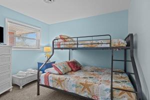 a bedroom with two bunk beds in a room at Colorful Emerald Isle Home Just Steps to Beach! in Emerald Isle