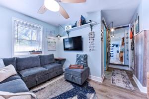 a living room with a couch and a tv at Dog-Friendly Jacksonville Beach Apt near Beach in Jacksonville Beach