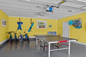 a ping pong table in a room with bikes at Colorful Emerald Isle Home Just Steps to Beach! in Emerald Isle