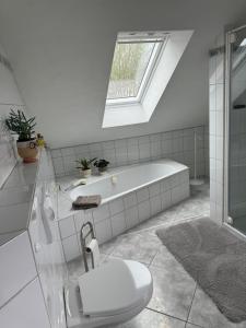 La salle de bains est pourvue d'une baignoire et de toilettes. dans l'établissement Ferienwohnung AUSZEIT, à Immenhausen
