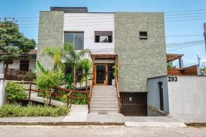a brick house with a wooden door at JQY Beach Flats - 950m da Praia - Garagem subterrânea - Estação de carregamento para veículos elétricos in Juquei