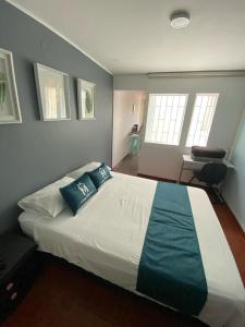 ボゴタにあるHotel Boutique Casa Magalyのベッドルーム(青い枕の大きな白いベッド付)