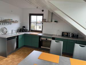 eine Küche mit grünen Schränken und einer Treppe in der Unterkunft Ferienwohnung AUSZEIT in Immenhausen