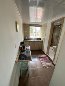 a small kitchen with a table and a bathroom at Hotel Boutique Casa Magaly in Bogotá