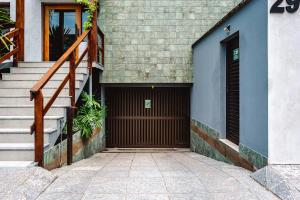 a building with a garage with a door and stairs at JQY Beach Flats - 950m da Praia - Garagem subterrânea - Estação de carregamento para veículos elétricos in Juquei