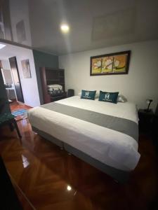 een slaapkamer met een groot wit bed met 2 kussens bij Hotel Boutique Casa Magaly in Bogota