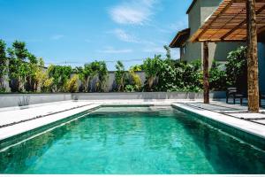a swimming pool in front of a house at JQY Beach Flats - 950m da Praia - Garagem subterrânea - Estação de carregamento para veículos elétricos in Juquei