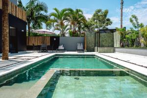 a swimming pool in the middle of a house at JQY Beach Flats - 950m da Praia - Garagem subterrânea - Estação de carregamento para veículos elétricos in Juquei +37 photos