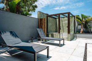two chairs and a bench on a patio at JQY Beach Flats - 950m da Praia - Garagem subterrânea - Estação de carregamento para veículos elétricos in Juquei