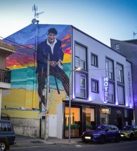 un mural de un hombre al lado de un edificio en Hotel Ancora Urban Center en Finisterre