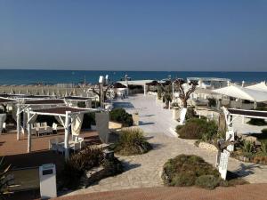 a beach with tables and umbrellas and the ocean at Ostia Lodge in Ostia Antica