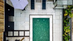 an overhead view of a swimming pool with an umbrella at JQY Beach Flats - 950m da Praia - Garagem subterrânea - Estação de carregamento para veículos elétricos in Juquei