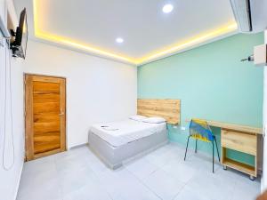 een slaapkamer met een bed, een bureau en een stoel bij Hotel Palma Grande by Stanza in Coveñas