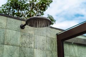 a shower on the side of a wall at JQY Beach Flats - 950m da Praia - Garagem subterrânea - Estação de carregamento para veículos elétricos in Juquei