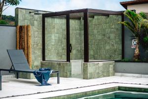 a patio with a chair next to a swimming pool at JQY Beach Flats - 950m da Praia - Garagem subterrânea - Estação de carregamento para veículos elétricos in Juquei