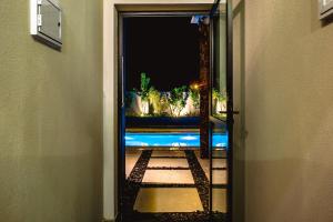 a hallway with a door to a room with plants at JQY Beach Flats - 950m da Praia - Garagem subterrânea - Estação de carregamento para veículos elétricos in Juquei