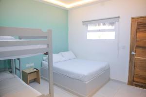 a bedroom with two bunk beds and a window at Hotel Palma Grande by Stanza in Coveñas