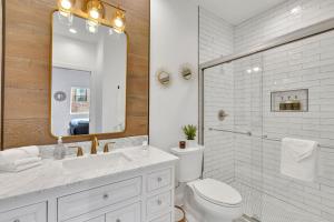 ein Badezimmer mit einem WC, einem Waschbecken und einem Spiegel in der Unterkunft Bright Modern 4Bd 2Ba in the Heart of Wrigleyville condo in Chicago