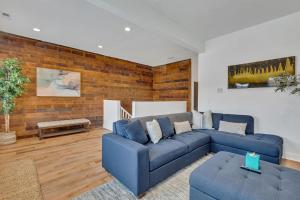 ein Wohnzimmer mit blauen Sofas und einer Ziegelwand in der Unterkunft Bright Modern 4Bd 2Ba in the Heart of Wrigleyville condo in Chicago