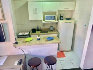 a small kitchen with a counter and a refrigerator at RAVENA 11 in Ribeirão Preto