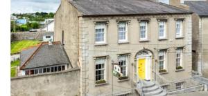 an old house with a yellow door on a building at Ashmore House in Cashel