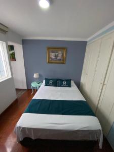 - une chambre avec un grand lit et un mur bleu dans l'établissement Hotel Boutique Casa Magaly, à Bogotá