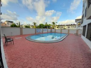 una piscina su un patio con sedia di Glo stays a Mombasa