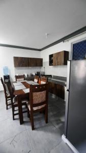 a kitchen with a table and chairs and a refrigerator at Glo stays in Mombasa