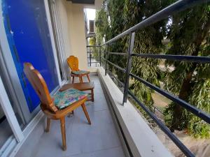 2 sillas sentadas en el balcón de una casa en Glo stays en Mombasa