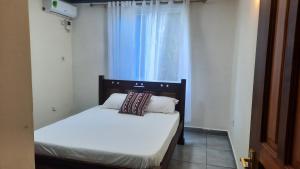 a small bedroom with two beds and a window at Glo stays in Mombasa