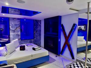 Habitación con 2 camas con luces azules en Cassino Motel 5, en Santo André