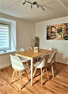 a dining room table and chairs in a room at modernes Landhaus Charlie - Nähe Halle, 4 Zimmer in Petersberg