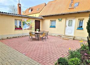 a patio with a table and chairs in front of a house at modernes Landhaus Charlie - Nähe Halle, 4 Zimmer in Petersberg