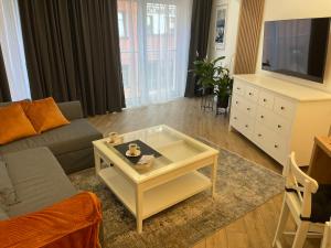 a living room with a couch and a coffee table at Apartament Komfort Promenada Ełk in Ełk
