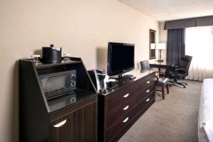 a hotel room with a television on a dresser at Concord Plaza Hotel in Concord