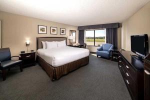 ein Hotelzimmer mit einem Bett und einem TV in der Unterkunft Concord Plaza Hotel in Concord