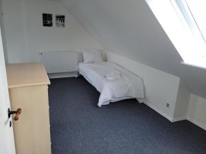 1 dormitorio con 1 cama con manta blanca en Skrædderens hus, en Assens
