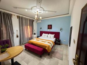 a bedroom with a large bed with a red headboard at SEGMAD HOTEL in Kribi
