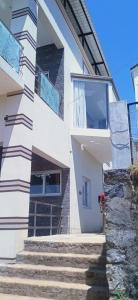 烏蒂的住宿－Sandy Luxury 4 Bhk Villa，前面有楼梯的白色建筑