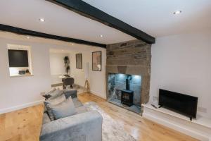 ein Wohnzimmer mit einem Sofa und einem Kamin in der Unterkunft FORD GATE - Modern Luxury Cottage based in Holmfirth in Holmfirth