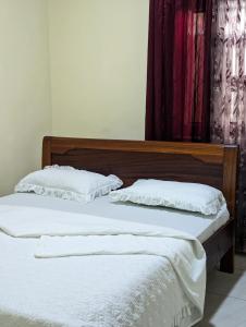 two beds with white pillows sitting next to each other at URBAN VIBER MOTEL in Kigali